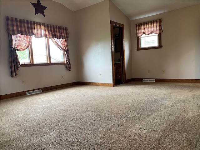 spare room with lofted ceiling and carpet flooring