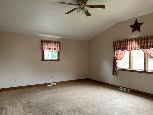 unfurnished room featuring carpet floors, lofted ceiling, ceiling fan, and a wealth of natural light