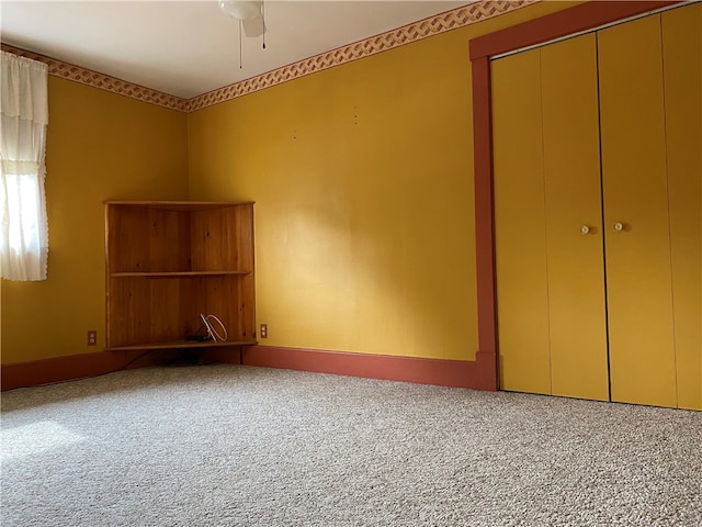 unfurnished bedroom with carpet floors, ceiling fan, and a closet