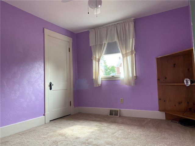 spare room featuring ceiling fan and carpet