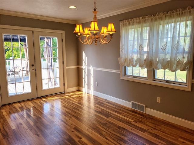 interior space featuring a notable chandelier, french doors, crown molding, and wood-type flooring