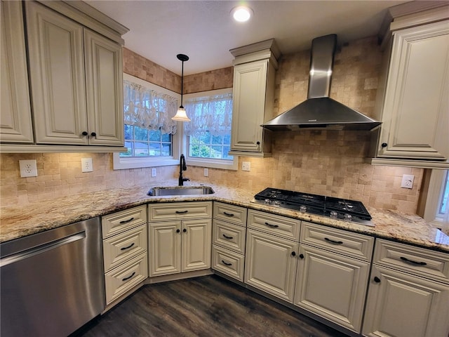 kitchen featuring stainless steel appliances, wall chimney exhaust hood, dark hardwood / wood-style floors, sink, and pendant lighting