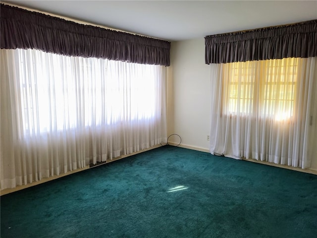 spare room featuring carpet floors and plenty of natural light