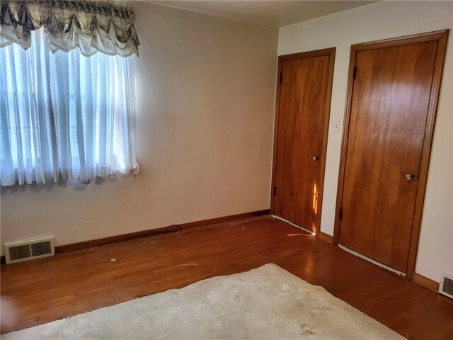 unfurnished bedroom featuring dark hardwood / wood-style flooring