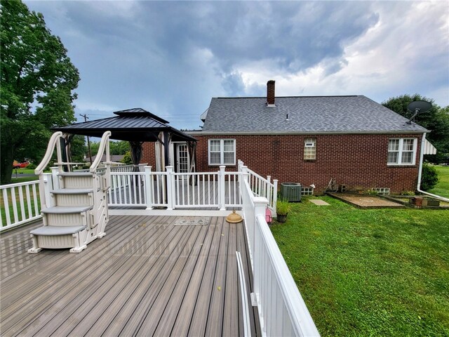 exterior space with a gazebo, a lawn, and central AC