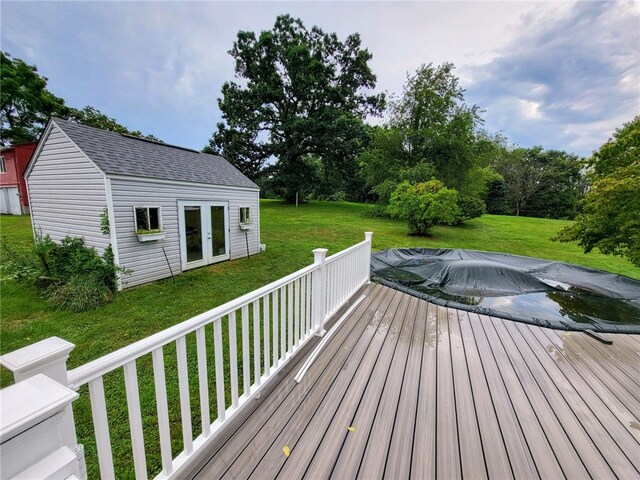 wooden deck featuring an outdoor structure and a yard