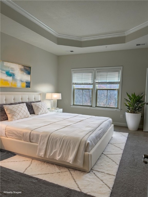 carpeted bedroom with a raised ceiling and crown molding