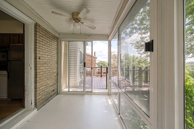 unfurnished sunroom featuring ceiling fan