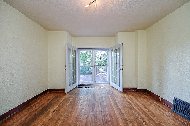 entryway featuring a textured ceiling, french doors, and wood-type flooring