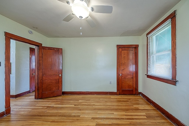 empty room with ceiling fan and light wood-type flooring