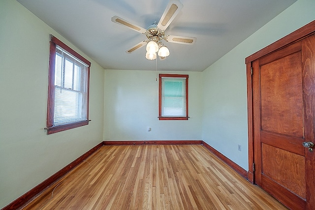 spare room with ceiling fan and light wood-type flooring