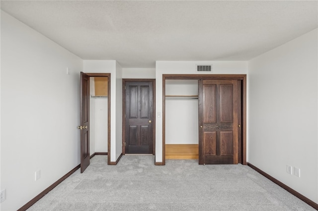 unfurnished bedroom featuring a closet and light colored carpet