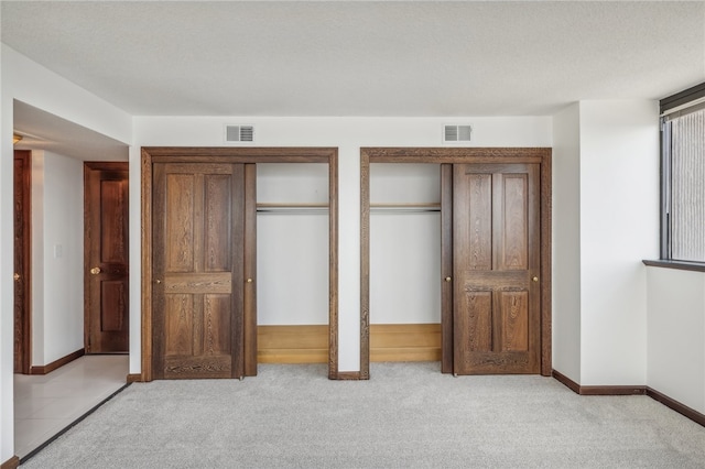 unfurnished bedroom featuring light carpet and a textured ceiling