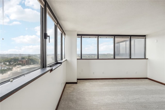 carpeted empty room featuring a textured ceiling