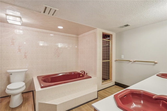 full bathroom with toilet, a textured ceiling, hardwood / wood-style flooring, and plus walk in shower