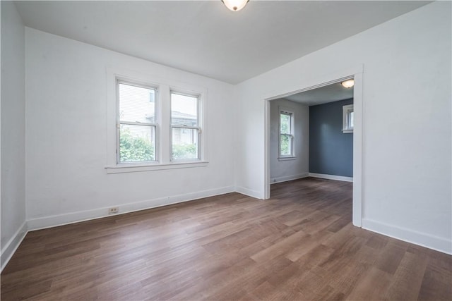 spare room featuring wood finished floors and baseboards