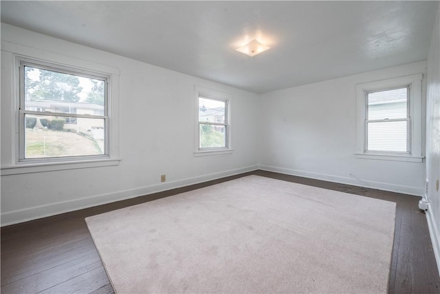 empty room with baseboards and dark wood-style flooring