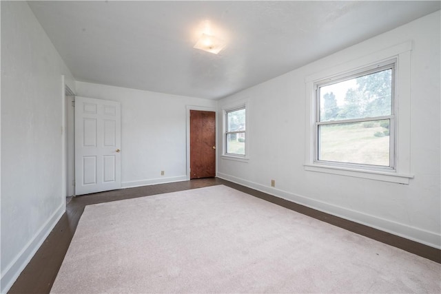 unfurnished bedroom with dark wood-type flooring and baseboards