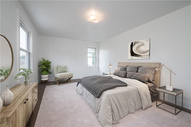 bedroom with baseboards and light colored carpet