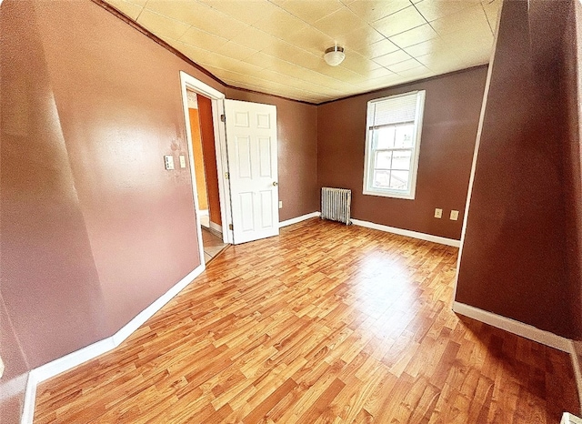 unfurnished bedroom featuring light hardwood / wood-style floors and radiator