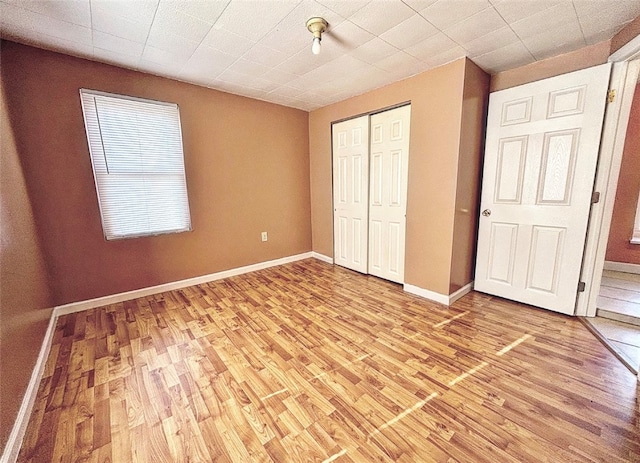 unfurnished bedroom featuring light wood-type flooring and a closet