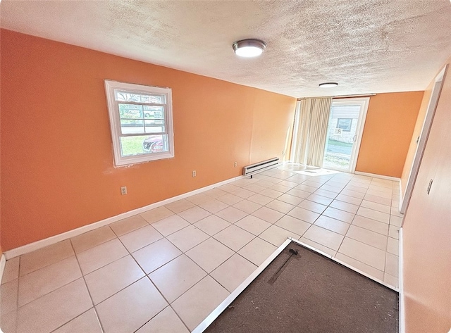 tiled spare room with a textured ceiling and baseboard heating