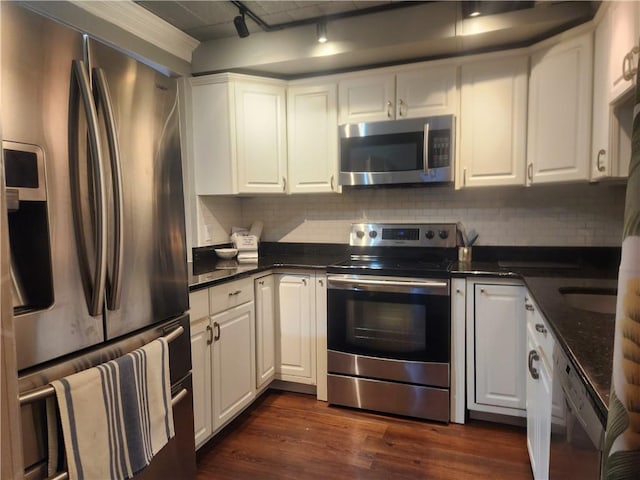 kitchen with decorative backsplash, appliances with stainless steel finishes, rail lighting, dark wood-type flooring, and white cabinetry