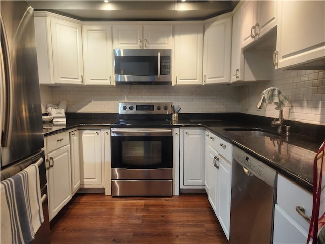 kitchen featuring backsplash, dark hardwood / wood-style flooring, white cabinets, and appliances with stainless steel finishes