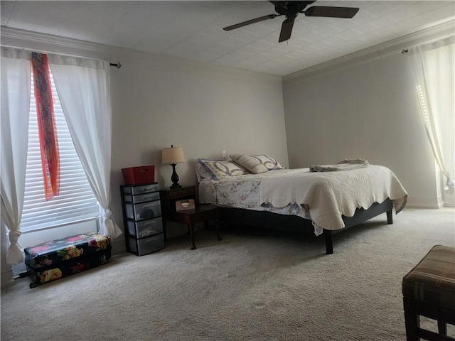 carpeted bedroom featuring ceiling fan and crown molding