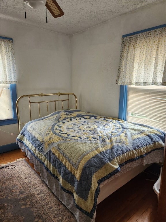 bedroom featuring a textured ceiling, ceiling fan, and hardwood / wood-style flooring