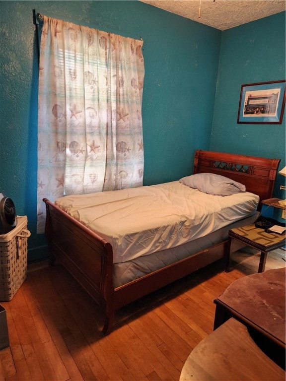 bedroom featuring hardwood / wood-style flooring and a textured ceiling