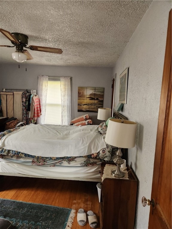 bedroom featuring ceiling fan, a textured ceiling, and hardwood / wood-style floors