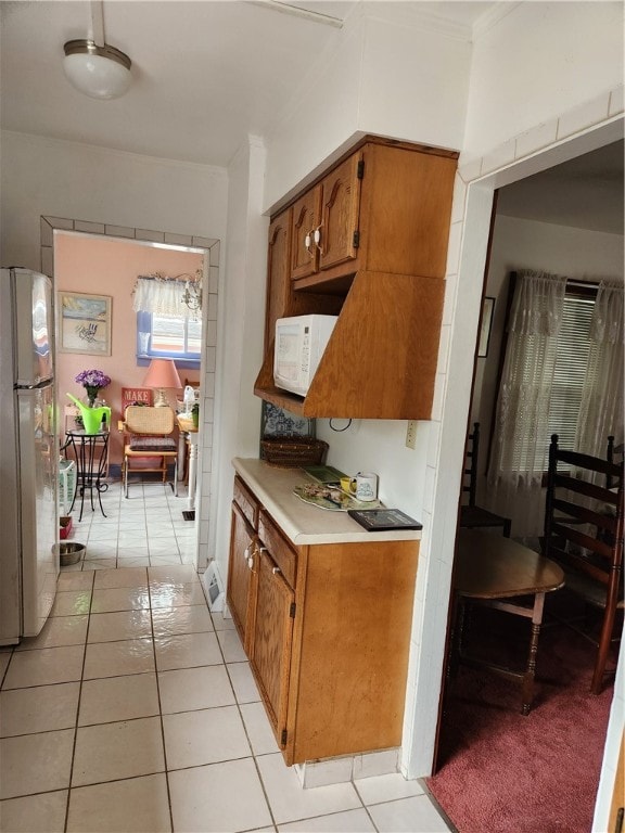 kitchen with stainless steel refrigerator and light tile patterned floors