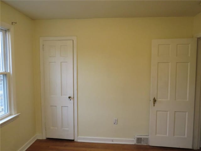 unfurnished bedroom with multiple windows, visible vents, and baseboards