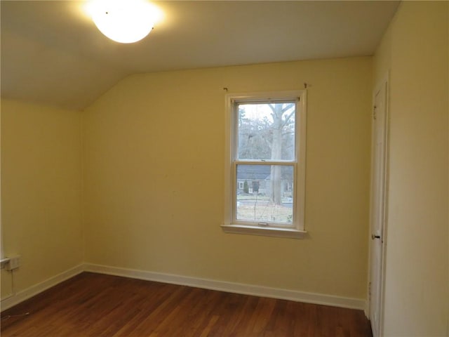 bonus room featuring dark wood-type flooring, lofted ceiling, and baseboards