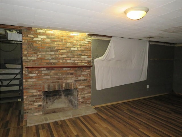 finished basement featuring a fireplace, baseboards, and wood finished floors