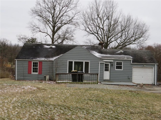 view of front of home featuring a front lawn, a chimney, and an attached garage