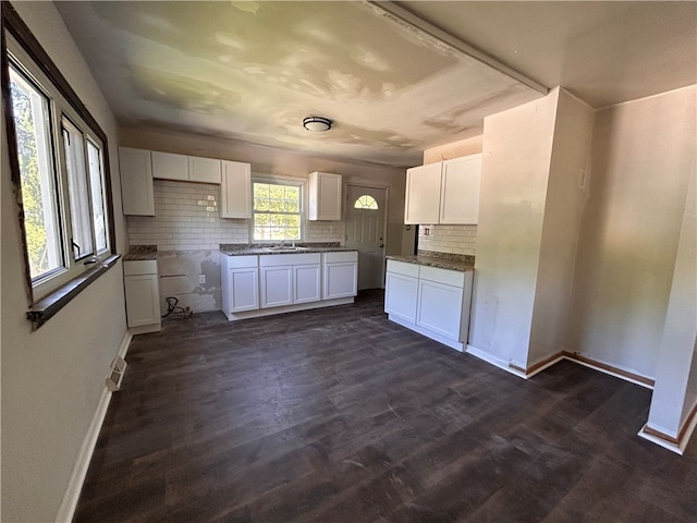 kitchen with sink, white cabinetry, dark hardwood / wood-style floors, and backsplash