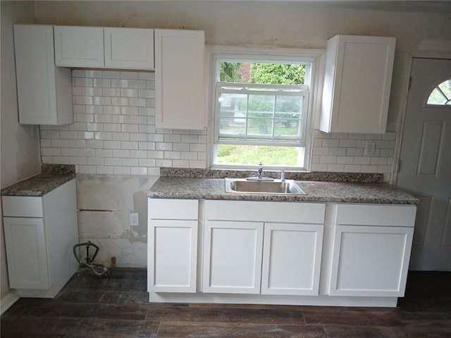 kitchen featuring sink, decorative backsplash, white cabinets, and dark hardwood / wood-style flooring