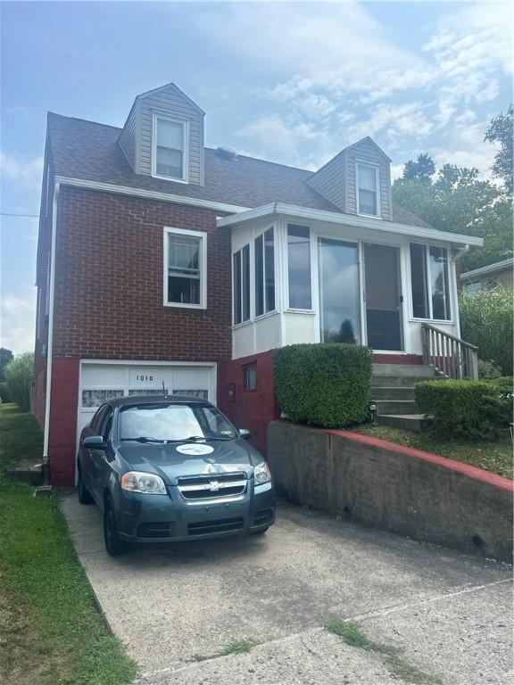 view of front facade featuring a garage, concrete driveway, and brick siding