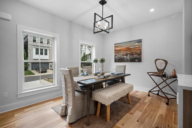 dining space with a notable chandelier and light hardwood / wood-style floors