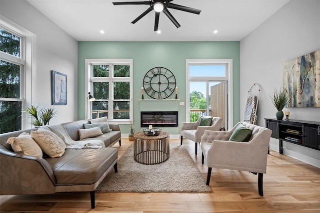 living room with ceiling fan, light hardwood / wood-style floors, and a healthy amount of sunlight