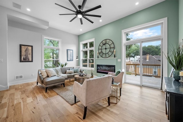 living room with light hardwood / wood-style flooring and ceiling fan