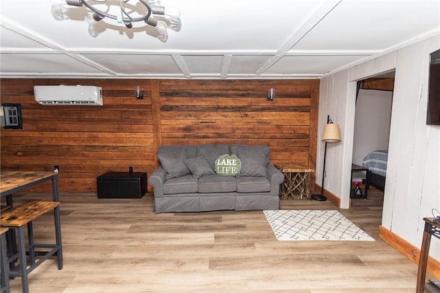 living area with an AC wall unit, wood walls, wood finished floors, and baseboards
