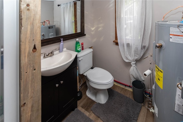 bathroom featuring toilet, water heater, vanity, and wood-type flooring