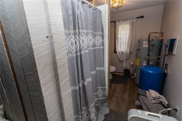 full bath with wood finished floors, water heater, curtained shower, and toilet