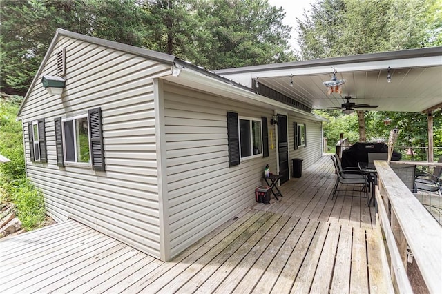 wooden deck featuring outdoor dining area and ceiling fan