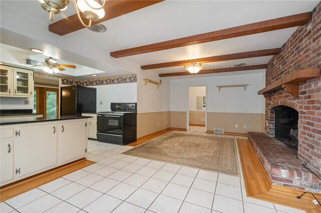 kitchen featuring light hardwood / wood-style flooring, white cabinetry, black appliances, a fireplace, and ceiling fan