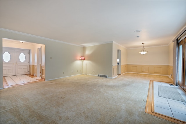 unfurnished living room featuring ornamental molding and light colored carpet