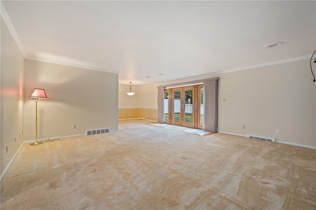 spare room featuring crown molding, french doors, and light carpet